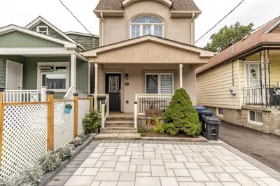 a house with a fence and a patio at 3BR Casa close to Woodbine Beach with deck area and WFH in Toronto
