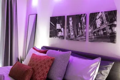 a purple room with a couch and some pillows at Luxury CN Tower View King Bed Balcony FREE PARK in Toronto