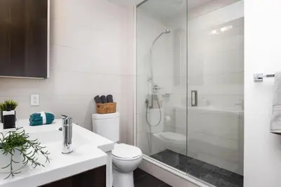 a bathroom with a shower and a toilet and a sink at Luxury CN Tower View King Bed Balcony FREE PARK in Toronto
