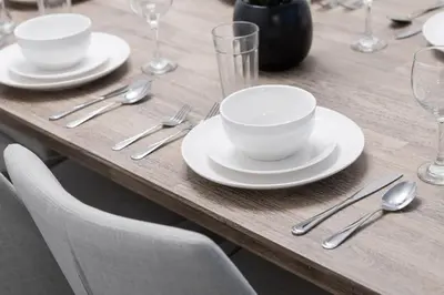 a wooden table with white plates and silverware on it at Urban APT with Highspeed WiFi Near shopping malls in Toronto