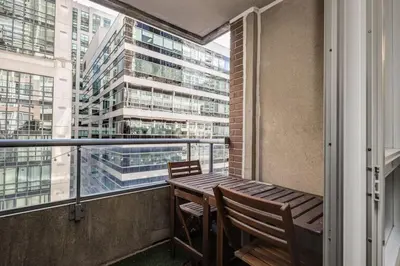 a balcony with a table and chairs and a building at Urban APT with Highspeed WiFi Near shopping malls in Toronto