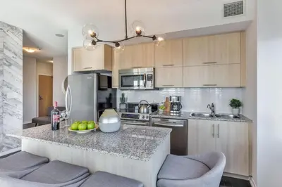 a kitchen with a counter with two bar stools at Skyline Waterfront 2BR plus 2BA wParking near MTCC in Toronto