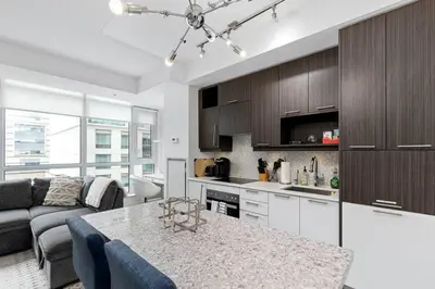 a kitchen and living room with a couch and a table at Comfy 2 BR 2 BA Ent District Work from home in Toronto