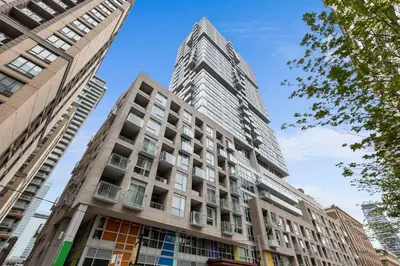 a tall building in front of two tall buildings at Comfy 2 BR 2 BA Ent District Work from home in Toronto