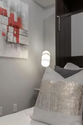 a bedroom with a bed with a lamp on it at Stunning 1BR and Den Sleeps 6 Steps From CN Tower in Toronto