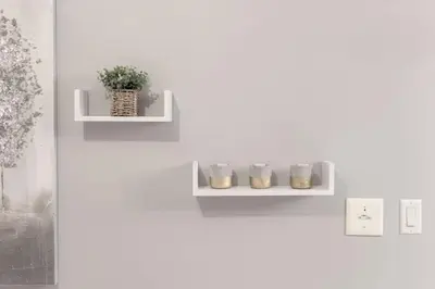 a white shelf on a white wall with a plant at Stunning 1BR and Den Sleeps 6 Steps From CN Tower in Toronto