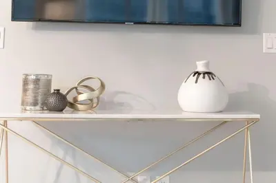 a white shelf with a television on a wall at Stunning 1BR and Den Sleeps 6 Steps From CN Tower in Toronto