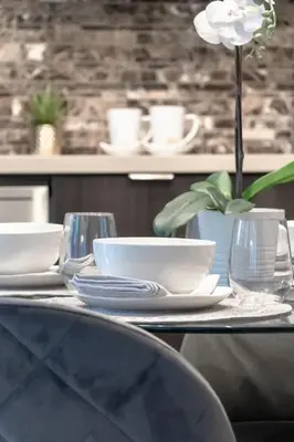 a table with plates and bowls and a flower on it at Stunning 1BR and Den Sleeps 6 Steps From CN Tower in Toronto