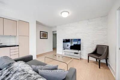 a living room with a couch and a television at 2BR Fantastic View of CN Tower and Roger Centre in Toronto