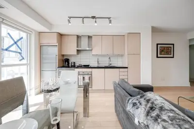 a kitchen and living room with a couch and a table at 2BR Fantastic View of CN Tower and Roger Centre in Toronto