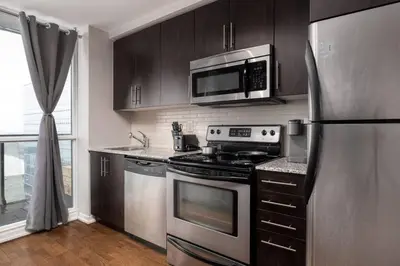 a kitchen with stainless steel appliances and a microwave at Urban Lifestyle 1BR Suite w CN Tower and Lake view in Toronto