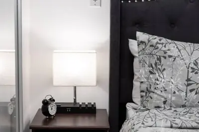 a bedroom with a bed and a table with a lamp at Urban Lifestyle 1BR Suite w CN Tower and Lake view in Toronto