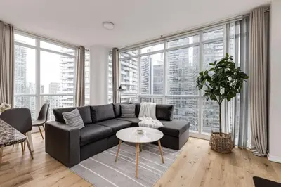 a living room with a couch and a table at Cozy Downtown 2BR Suite near CN Tower with Balcony in Toronto