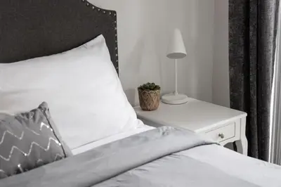 a bedroom with a bed with a nightstand and a lamp at Cozy Downtown 2BR Suite near CN Tower with Balcony in Toronto