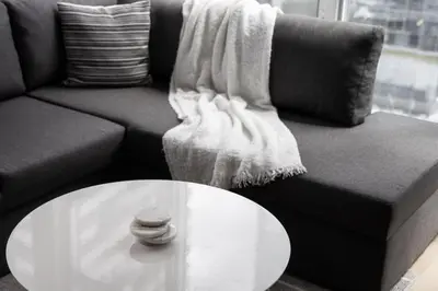 a living room with a couch and a white table at Cozy Downtown 2BR Suite near CN Tower with Balcony in Toronto