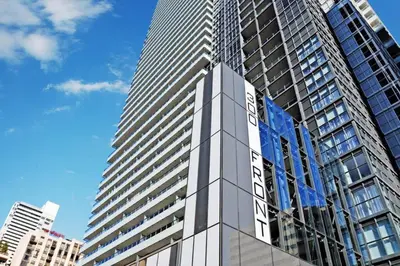 a tall building with a sign on the side of it at 3BR Rooftop Pool Gym Steps to MTCC and CN Tower with Parking in Toronto
