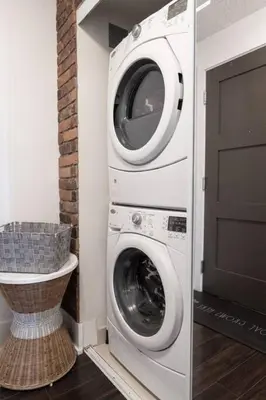 a washer and dryer in a room with a door at 3BR Rooftop Pool Gym Steps to MTCC and CN Tower with Parking in Toronto