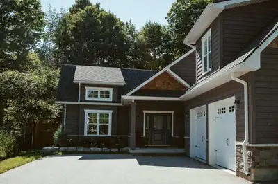 a house with a driveway and a garage at Beach House 5 Star Gem with a Muskoka room and Yoga Studio in Innisfil