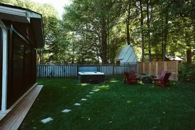 a backyard with a ping pong table in the grass at Beach House 5 Star Gem with a Muskoka room and Yoga Studio in Innisfil