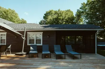 a group of chairs on a deck in front of a house at Beach House 5 Star Gem with a Muskoka room and Yoga Studio in Innisfil