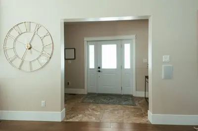a large clock on a wall next to a door at Beach House 5 Star Gem with a Muskoka room and Yoga Studio in Innisfil