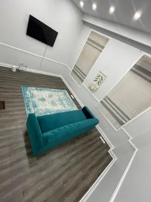 a living room with a blue couch and a tv at Triple M Lodge Master Bedroom in Mississauga