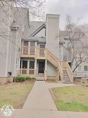 a large white house with a porch and a deck at Blue Mountain, Collingwood - Loft Condo, sleeps 4 in Blue Mountains