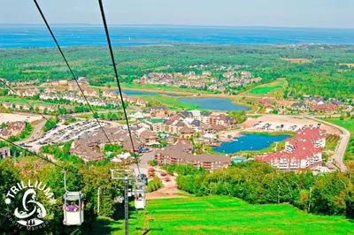 a gondola ride over a town and a lake at Blue Mountain, Collingwood - Loft Condo, sleeps 4 in Blue Mountains