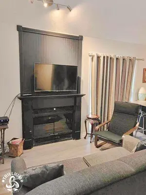 a living room with a fireplace and a television at Blue Mountain, Collingwood - Loft Condo, sleeps 4 in Blue Mountains