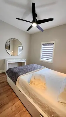 a bedroom with a bed and a ceiling fan at The Zen Escape Modern Queen Size One Bedroom Full Apartment in St. Catharines