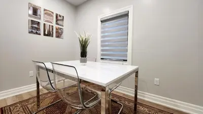 a white table and chairs in a room with a window at The Cozy Cove Modern King-Bedroom Full Apartment in St. Catharines