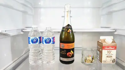 a bottle of wine and two bottles of water on a counter at The Cozy Cove Modern King-Bedroom Full Apartment in St. Catharines