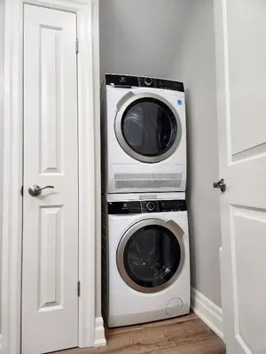 a microwave and a washer and dryer in a room at The Cozy Cove Modern King-Bedroom Full Apartment in St. Catharines