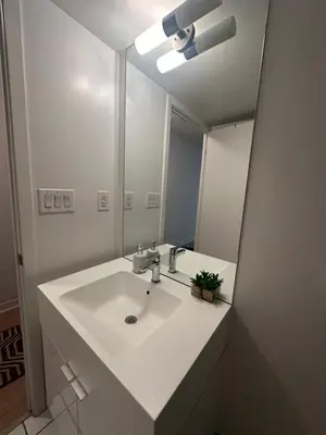 a bathroom with a white sink and a mirror at Downtown Toronto Condo Suite in Toronto