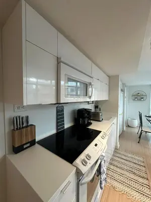 a kitchen with white cabinets and a black counter top at Downtown Toronto Condo Suite in Toronto