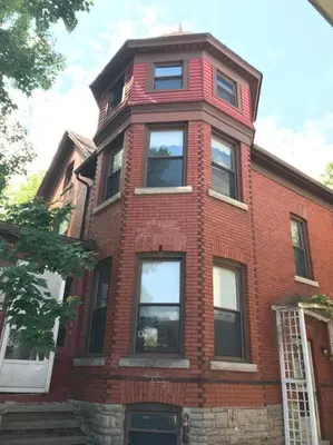 a red brick building with windows on a street at Vintage cute house 5 min from the beautiful Falls! in Niagara Falls