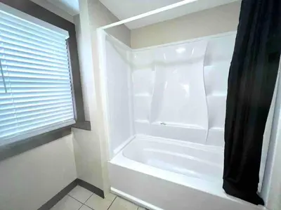 a white bath tub in a bathroom with a window at Vintage cute house 5 min from the beautiful Falls! in Niagara Falls