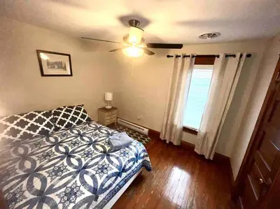 a bedroom with a bed and a ceiling fan at Vintage cute house 5 min from the beautiful Falls! in Niagara Falls