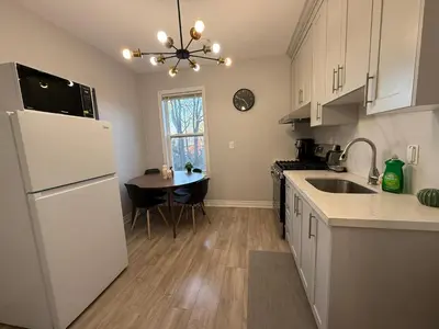 a kitchen with a white refrigerator and a table at Family-Friendly 3BR in Little Italy in Toronto