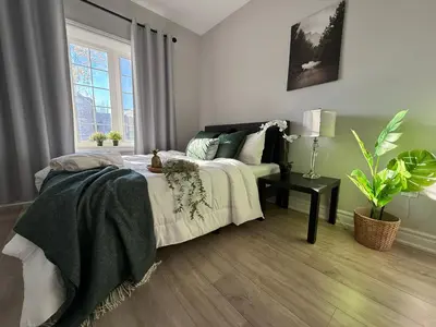 a bedroom with a bed and a table and a window at Family-Friendly 3BR in Little Italy in Toronto
