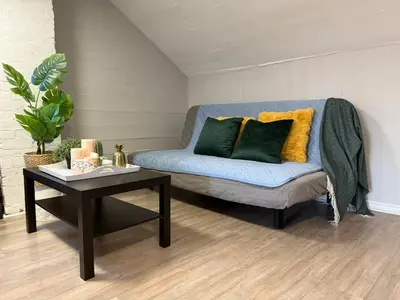 a blue couch with two pillows and a table at Family-Friendly 3BR in Little Italy in Toronto