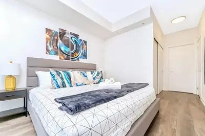 a white bedroom with a bed and a white ceiling at Luxurious 1BR Condo - Stunning City Views in Kitchener
