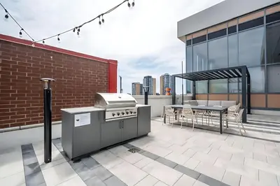 a patio with a grill and a table on a building at Luxurious 1BR Condo - Stunning City Views in Kitchener