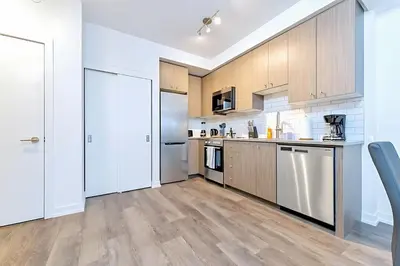 a kitchen with wooden cabinets and stainless steel appliances at Luxurious 1BR Condo - Stunning City Views in Kitchener