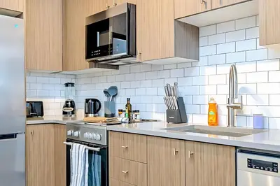 a kitchen with a sink and a microwave at Luxurious 1BR Condo - Stunning City Views in Kitchener