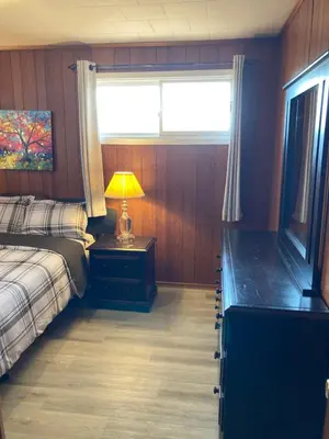 a bedroom with a bed and a lamp on a table at Lucky home- Vacation Houses in Trenton