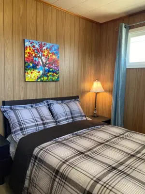 a bedroom with a bed and a painting on the wall at Lucky home- Vacation Houses in Trenton
