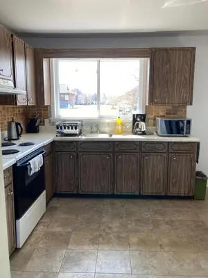 a kitchen with wooden cabinets and a sink and a window at Lucky home- Vacation Houses in Trenton