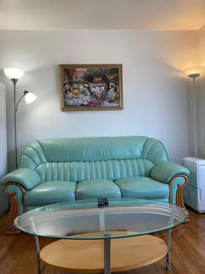 a living room with a green couch and a glass table at Lucky home- Vacation Houses in Trenton