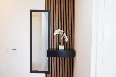 a mirror and a vase with flowers on a wall at Modern luxury Waterfront Condo in Mississauga